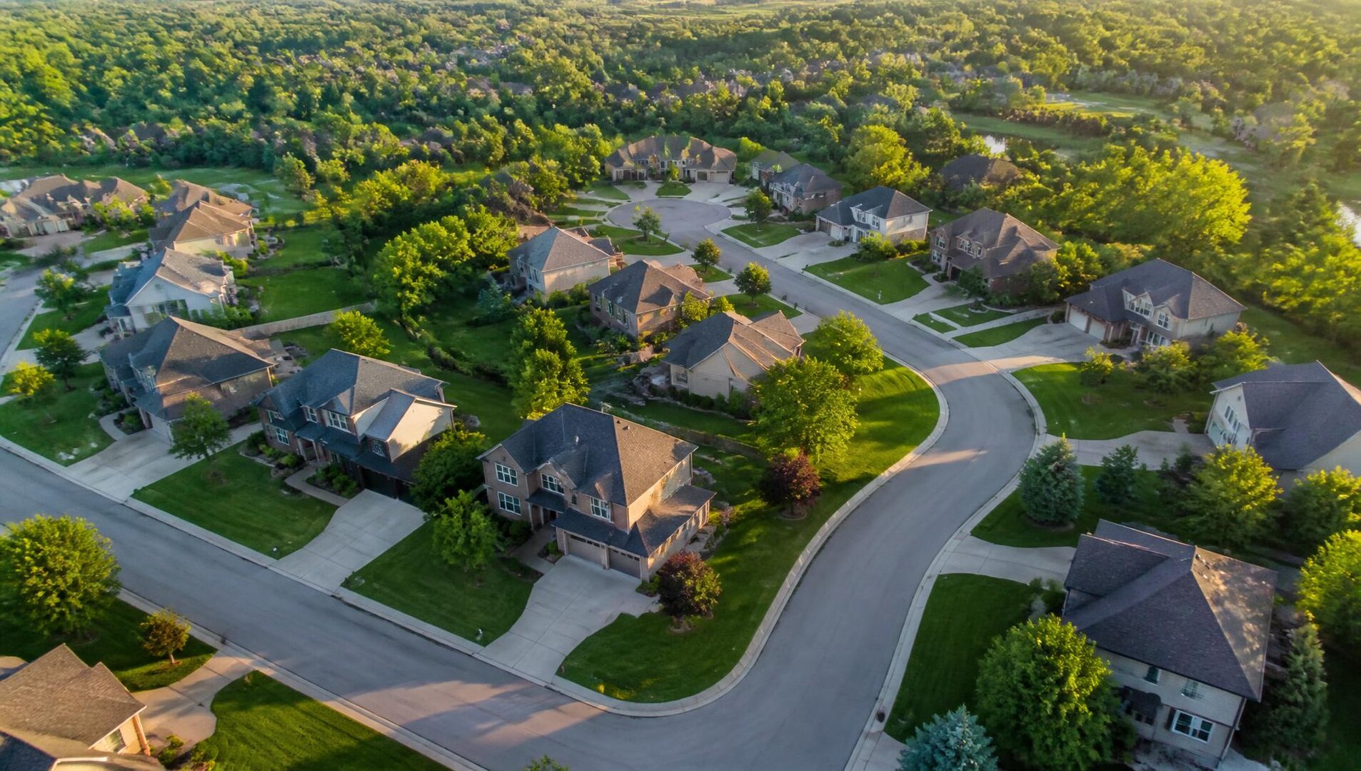 Aerial view of a suburban HOA subdivision with homes, streets, and green space